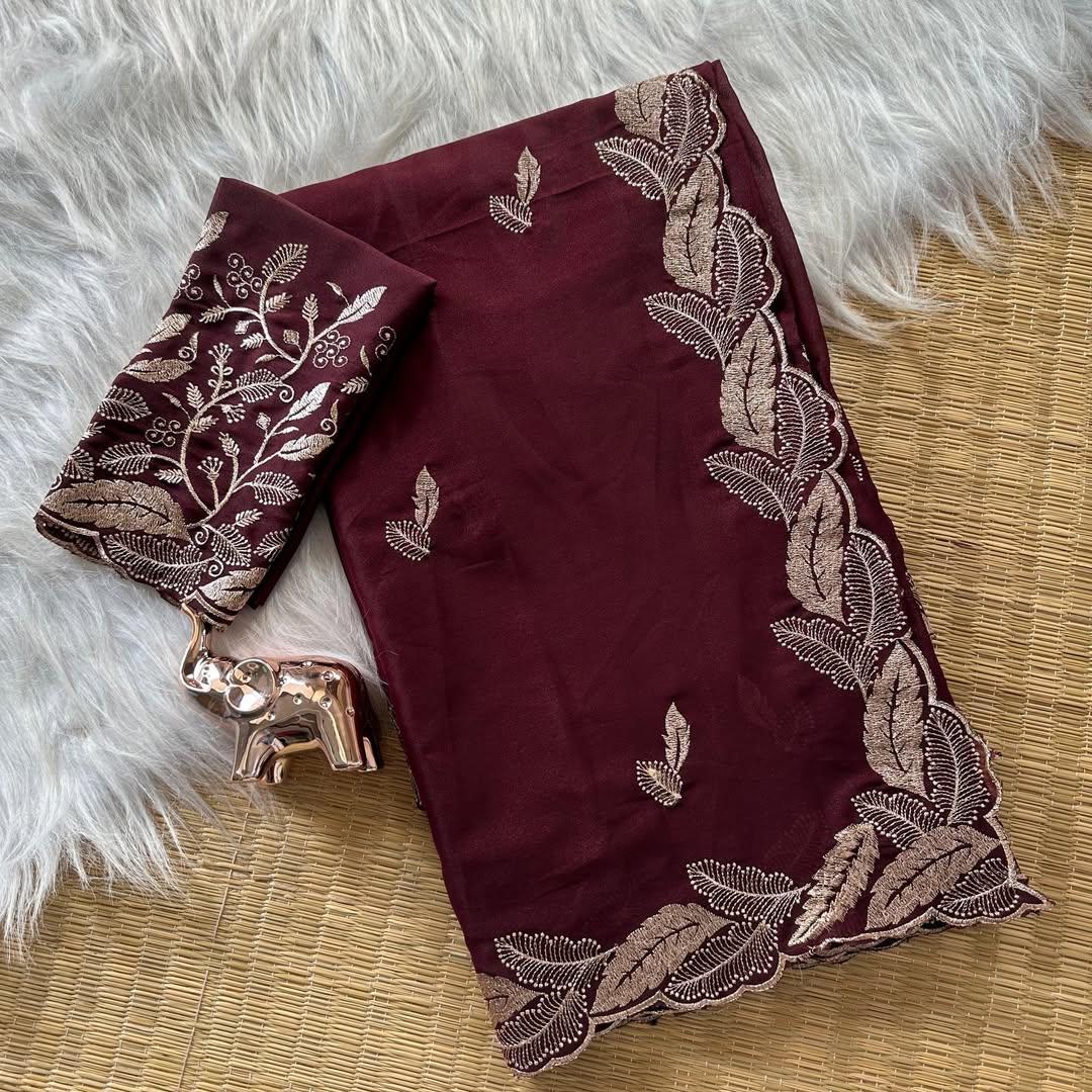 Maroon fabric with gold embroidery on a textured surface