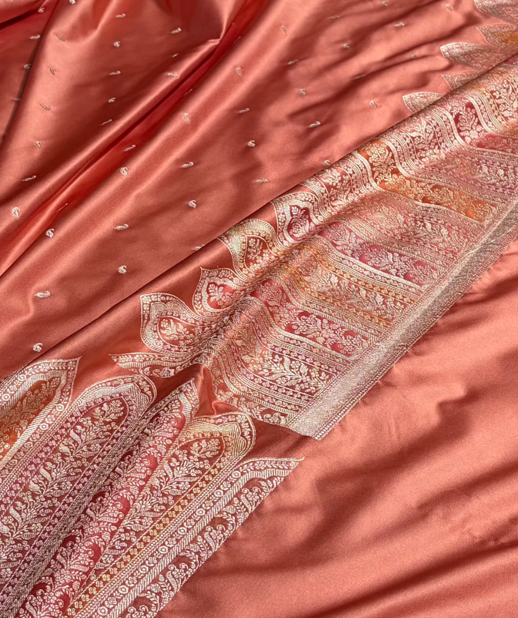 Close-up of a pink saree with intricate patterns and embellishments.