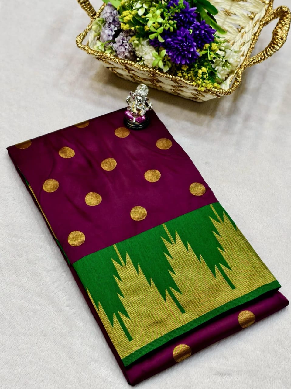 Purple and green saree with gold polka dots on a light gray background