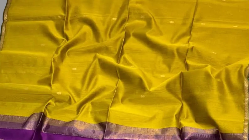 Purple and yellow saree with a floral decoration on a white background