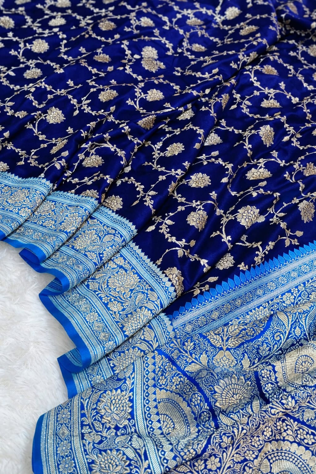 Blue saree with white floral patterns on a textured surface