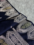 Navy blue fabric with intricate white and gold embroidery on a textured gray background