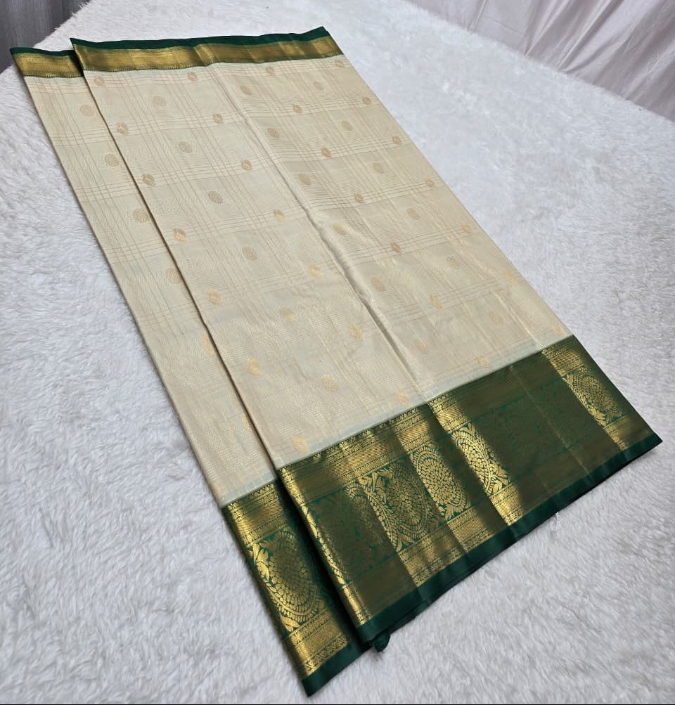 Traditional saree with green border on a white surface