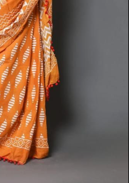 Orange saree with white patterns on a gray background