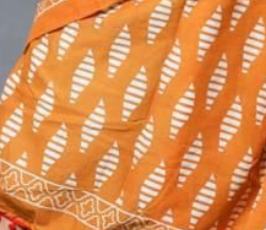 Close-up of a patterned fabric with yellow and white design