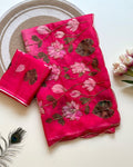 Pink Tebby silk saree with pink lotus digital floral prints, green leaf motifs, gold-tone Katdana detailing, scalloped edges and a matching running blouse.