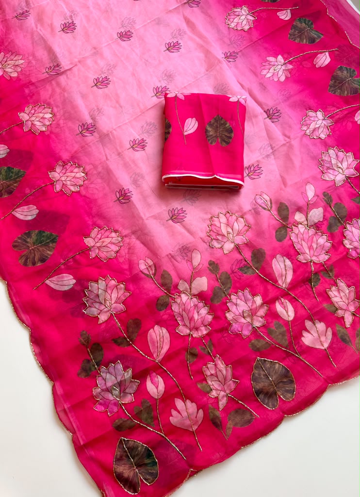 Pink Tebby silk saree with pink lotus digital floral prints, green leaf motifs, gold-tone Katdana detailing, scalloped edges and a matching running blouse.