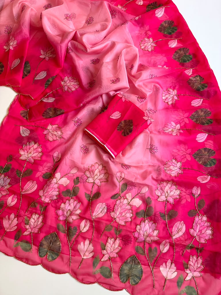 Pink Tebby silk saree with pink lotus digital floral prints, green leaf motifs, gold-tone Katdana detailing, scalloped edges and a matching running blouse.