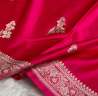 Close-up of a pink fabric with intricate white embroidery
