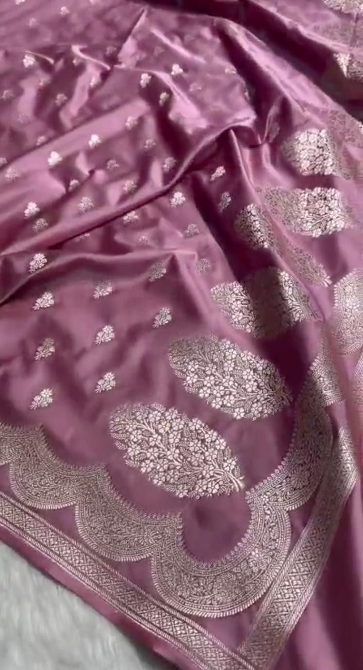 Pink fabric with silver embroidery on a light gray background