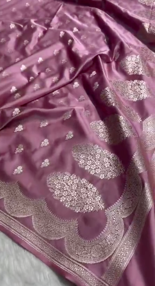 Pink fabric with silver embroidery on a light gray background