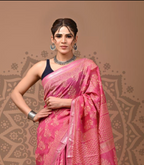 Woman wearing a pink saree with a decorative background