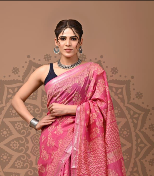 Woman wearing a pink saree with a decorative background
