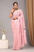 Woman wearing a pink saree with a floral pattern against a neutral background