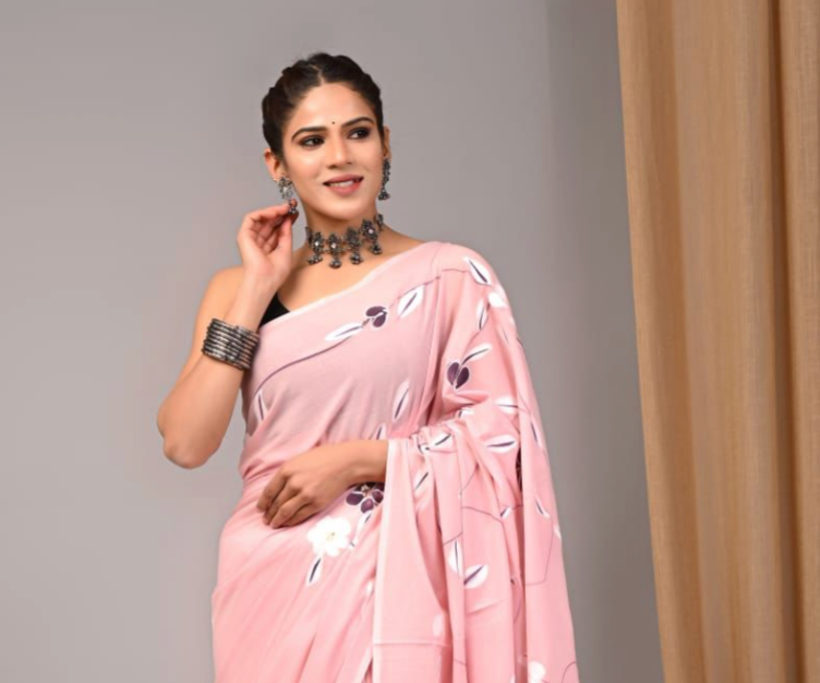 Woman wearing a pink saree with a gray background
