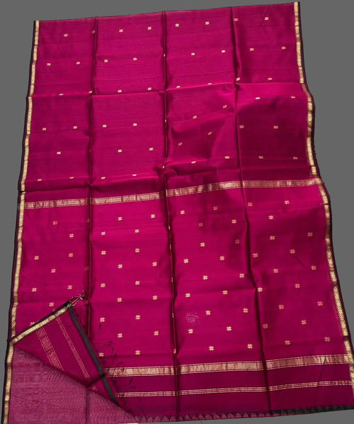 Pink saree with gold border on a white floor
