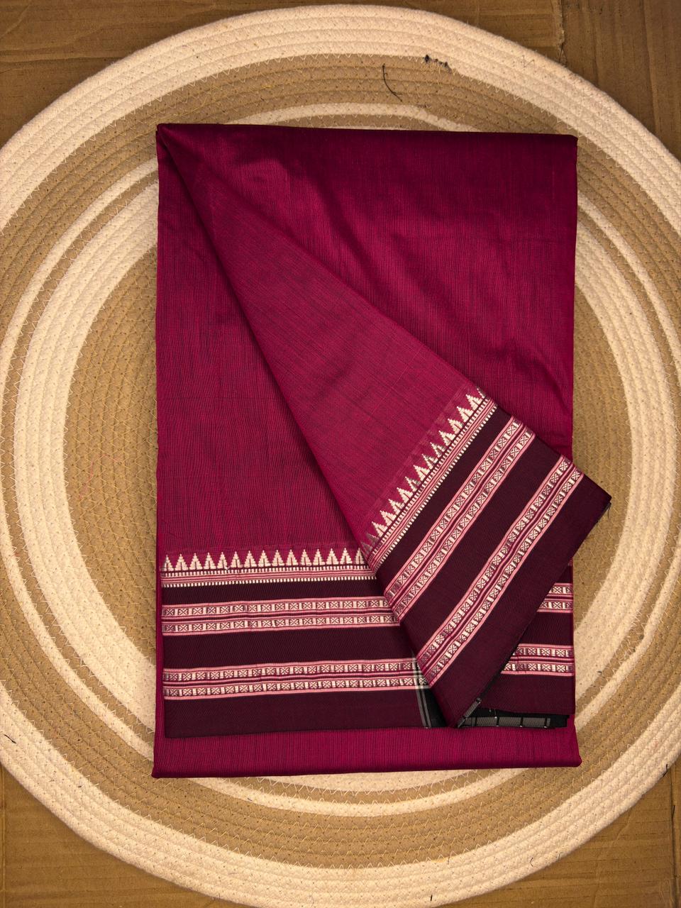 Folded maroon fabric with geometric patterns on a circular wooden surface