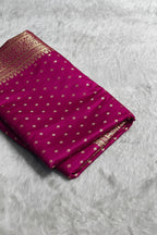 Purple saree with gold patterns on a white surface, branded 'ZIVRA'.