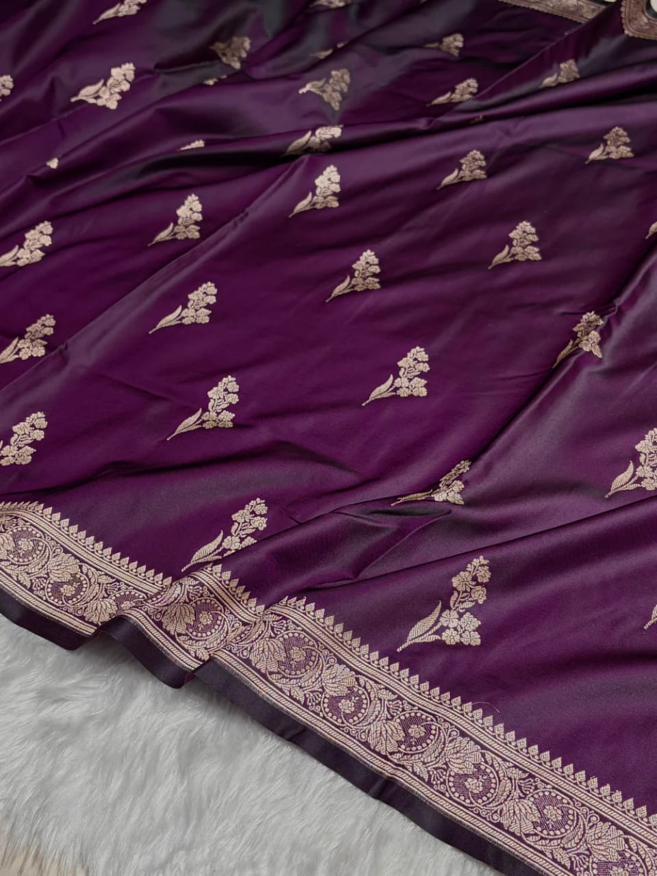 Purple fabric with gold embroidery on a light gray background