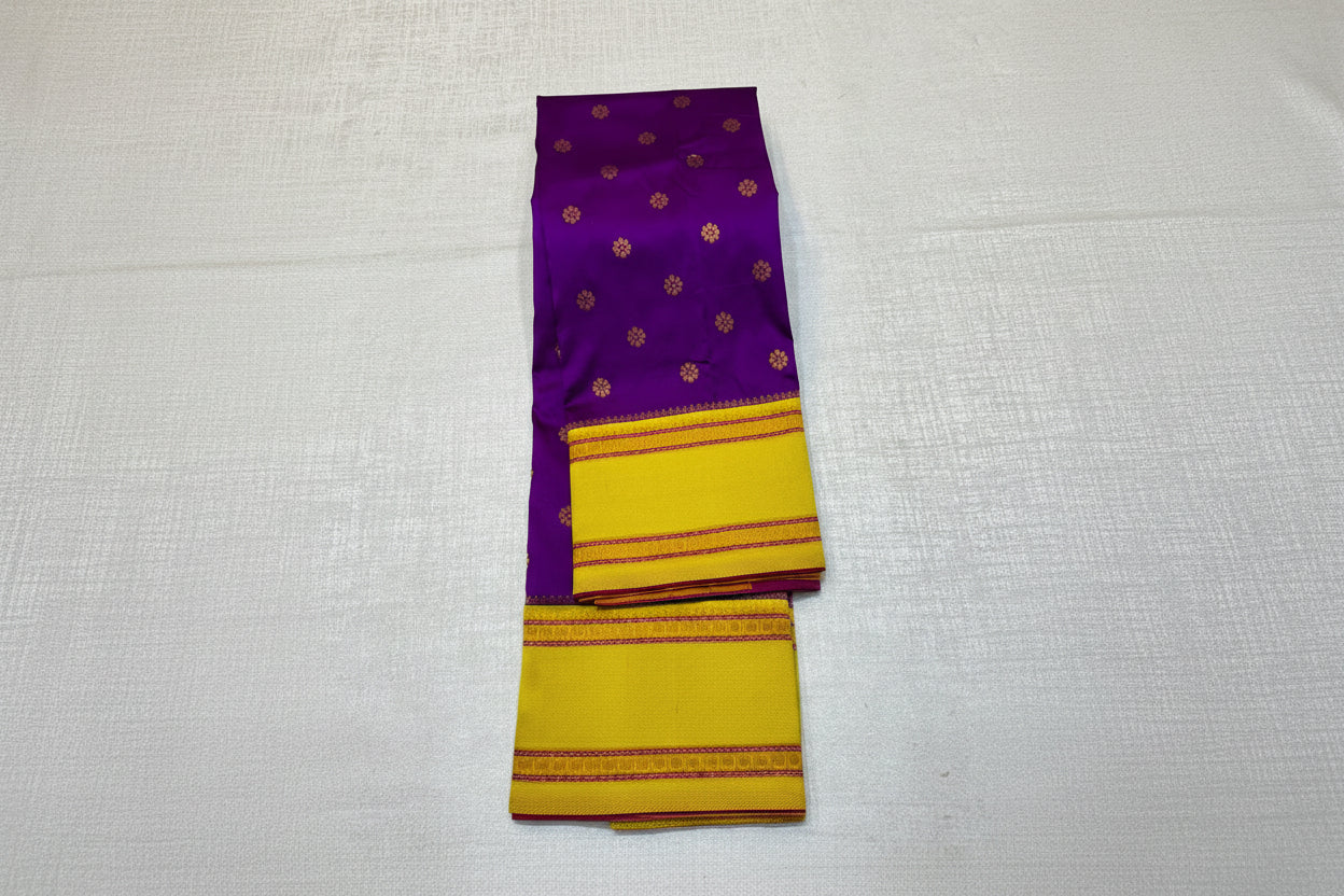 Purple and yellow saree with floral decorations on a light gray background