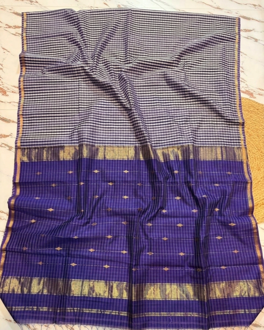 Blue saree with a checkered pattern and gold border on a wooden surface