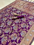 Purple saree with gold and white floral patterns on a plain background