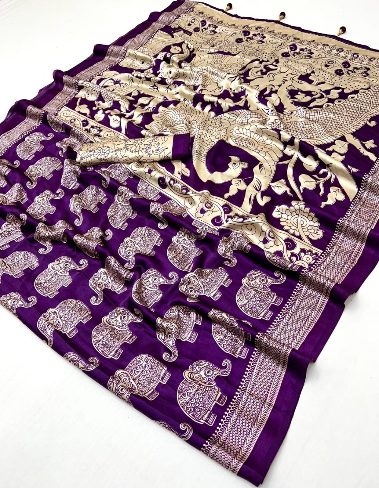 Purple fabric with silver elephant patterns and intricate designs on a white background