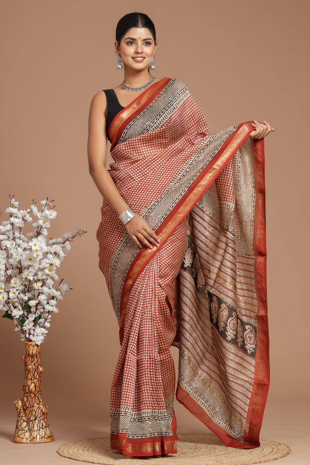 Woman wearing a traditional saree with a vase of flowers on a beige background