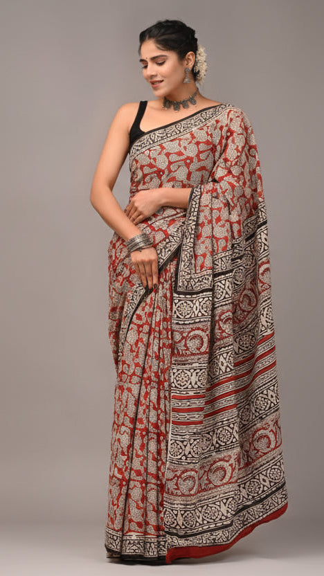Woman wearing a patterned saree with a neutral background