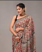 Woman wearing a patterned saree against a plain background