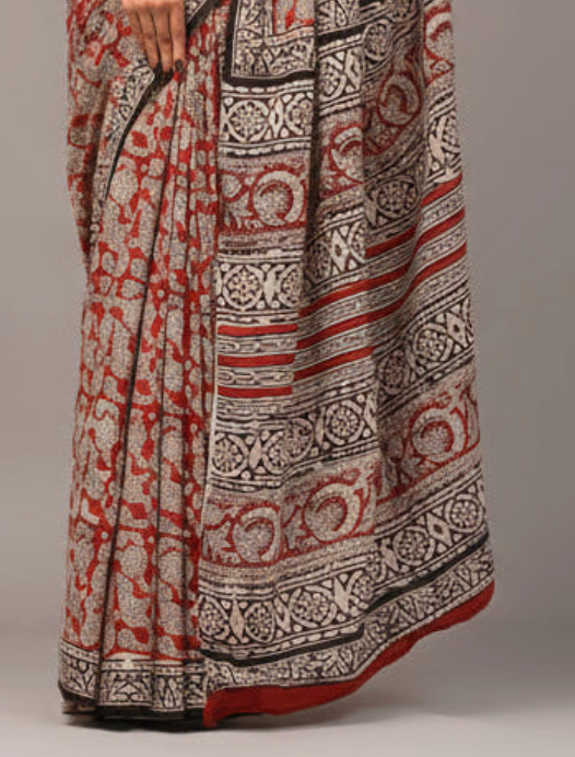 Long patterned dress with red, white, and black design on a plain background