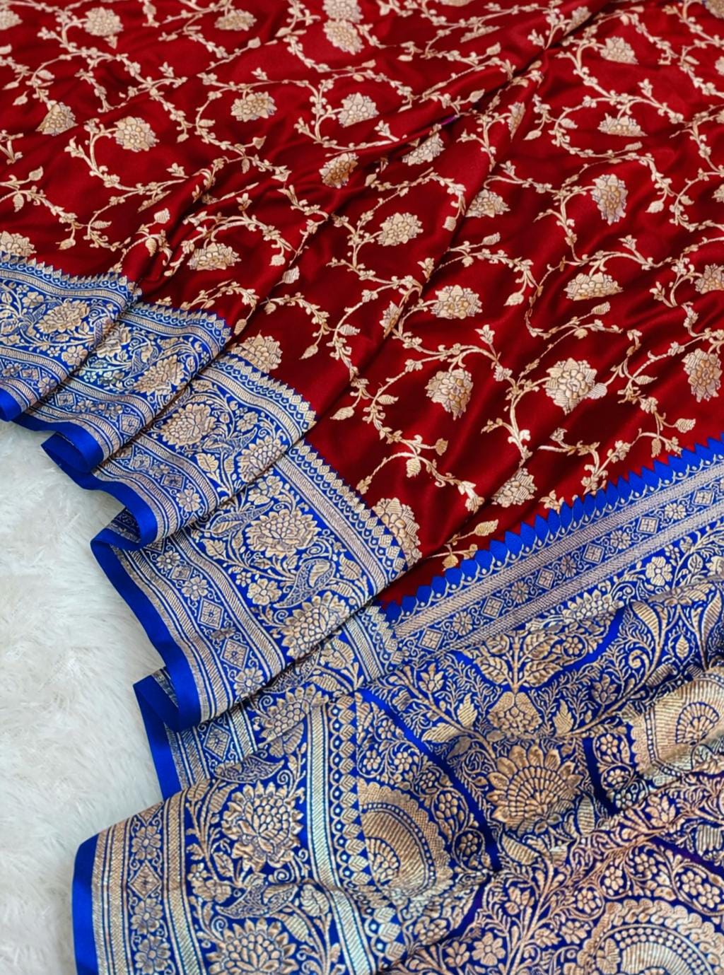 Red and blue saree with intricate patterns on a white background