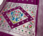 Purple and white saree with floral patterns on a plain background