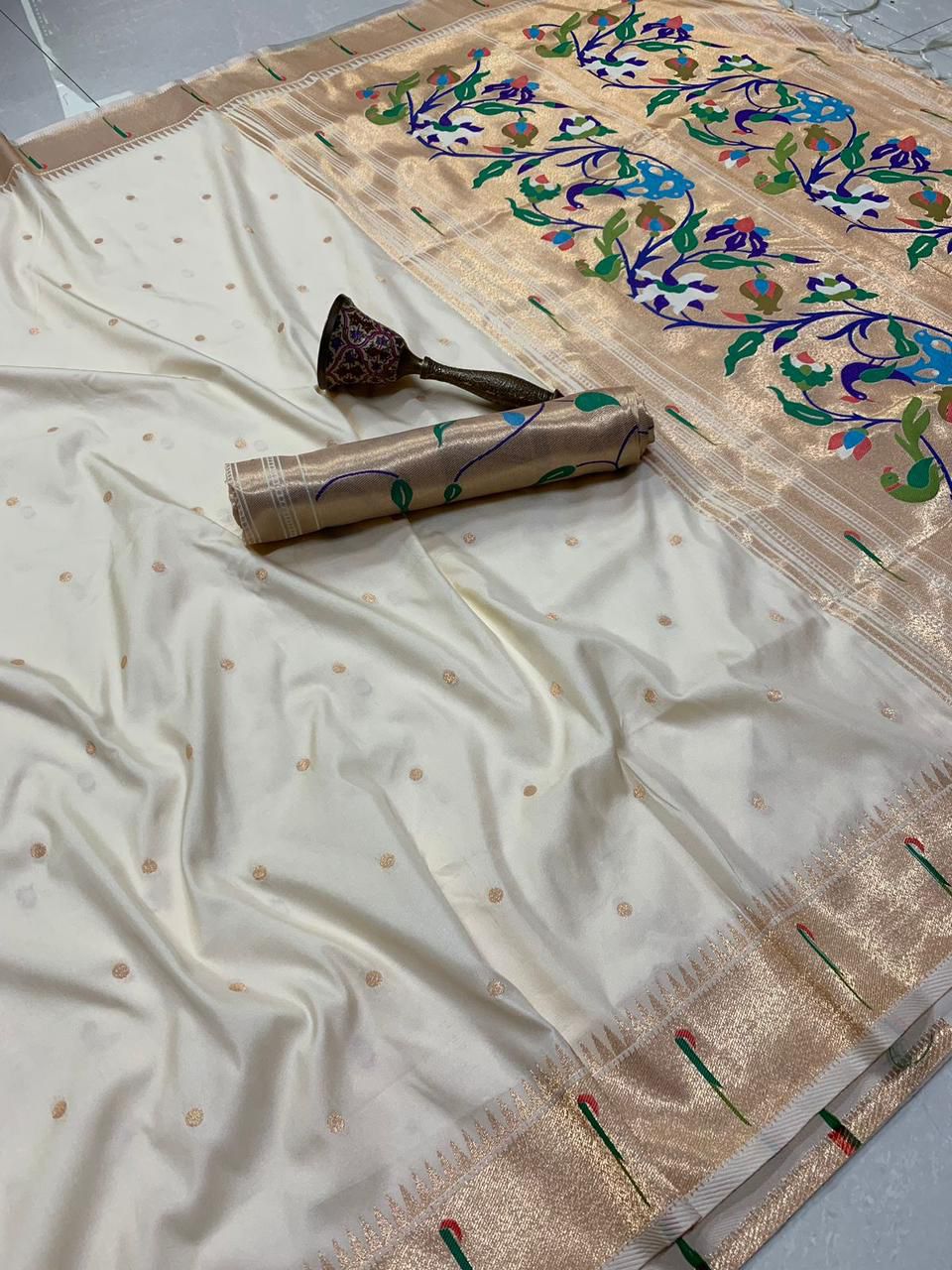 White saree with gold border and floral patterns on a plain background