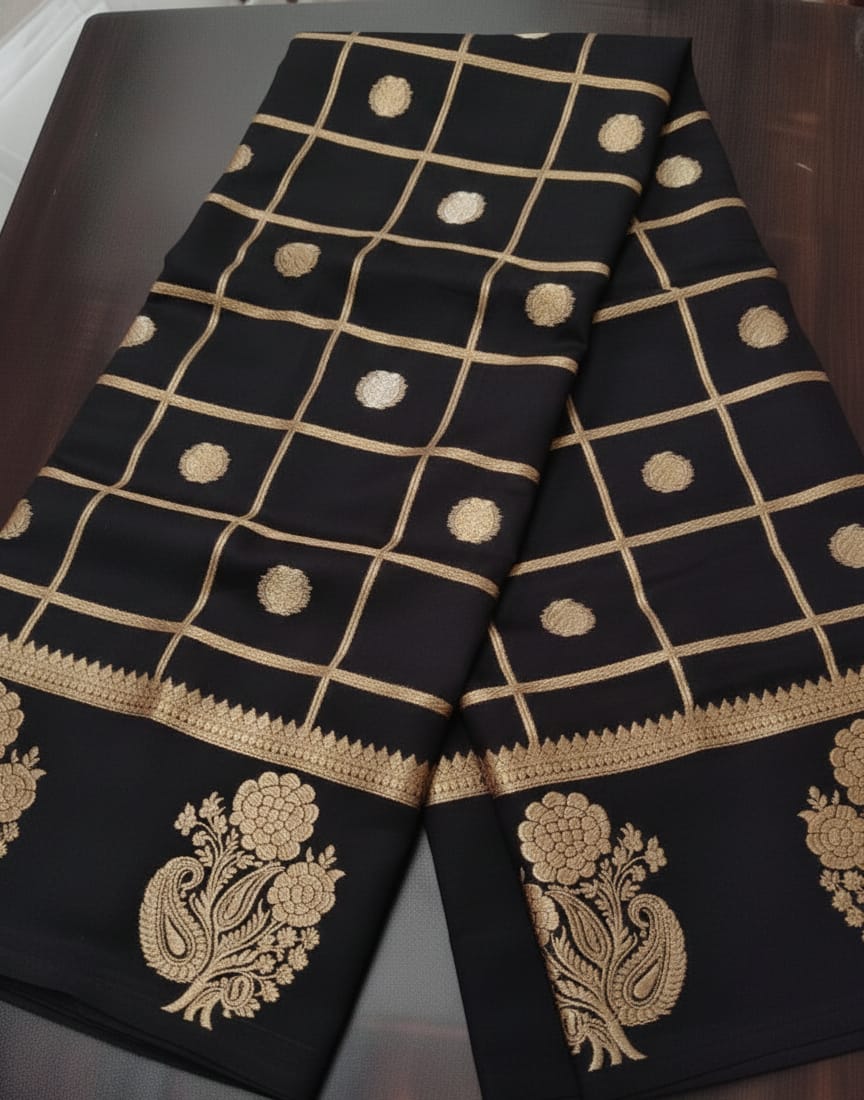 Black fabric with gold embroidery and patterns on a dark surface