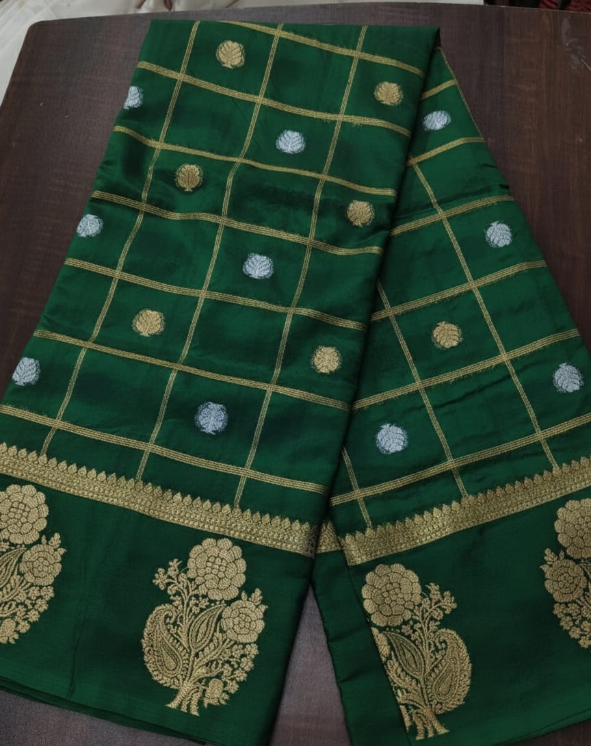 Green fabric with gold embroidery on a wooden surface