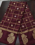 Maroon fabric with gold embroidery on a dark surface