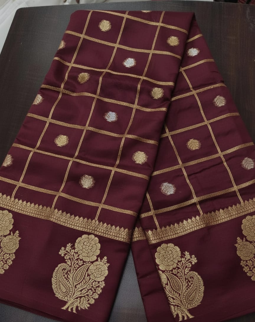 Maroon fabric with gold embroidery on a dark surface