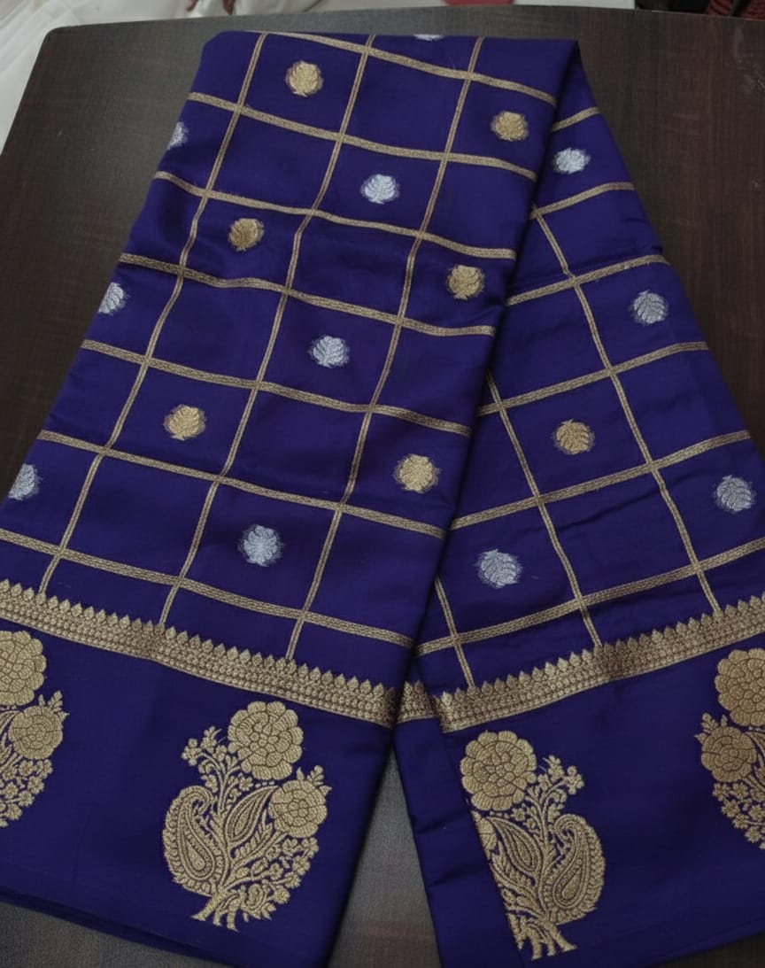 Blue fabric with gold embroidery on a dark surface