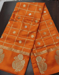 Orange fabric with gold embroidery on a dark surface