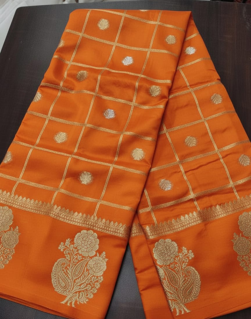 Orange fabric with gold embroidery on a dark surface