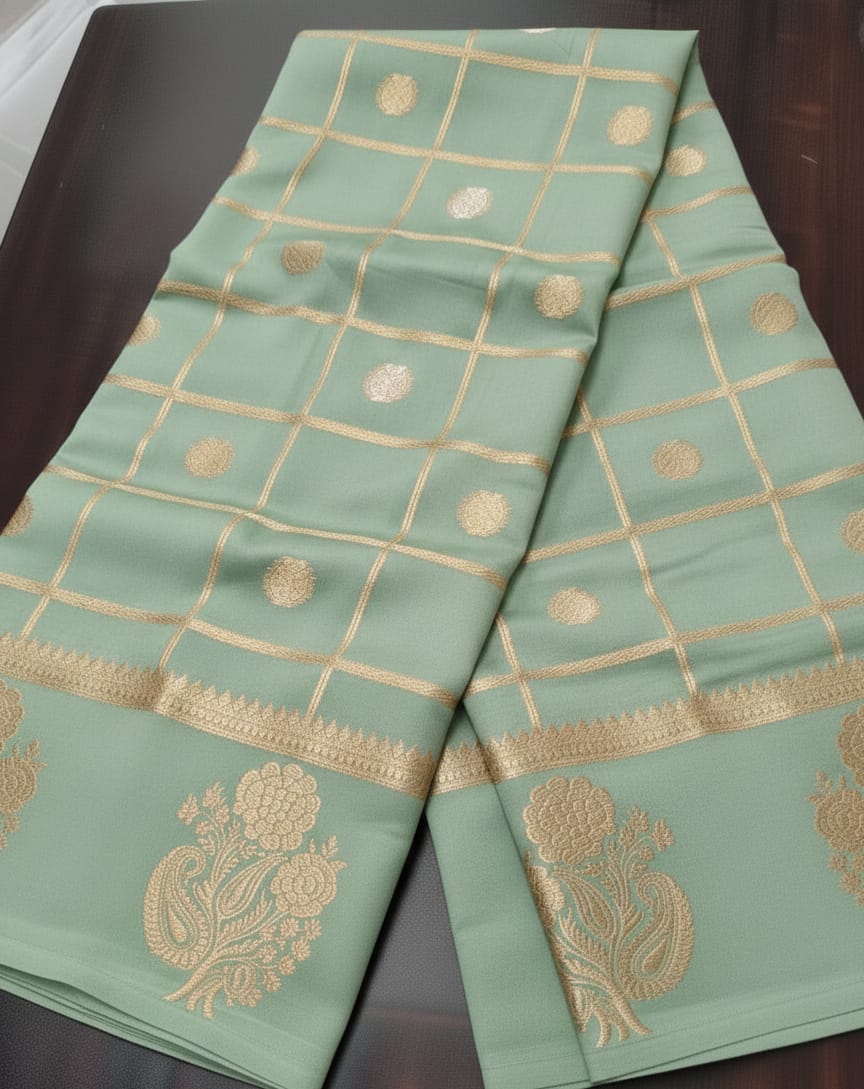 Light green fabric with gold embroidery on a dark surface