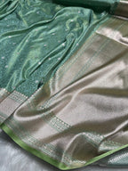 Green and silver saree with intricate patterns on a white background