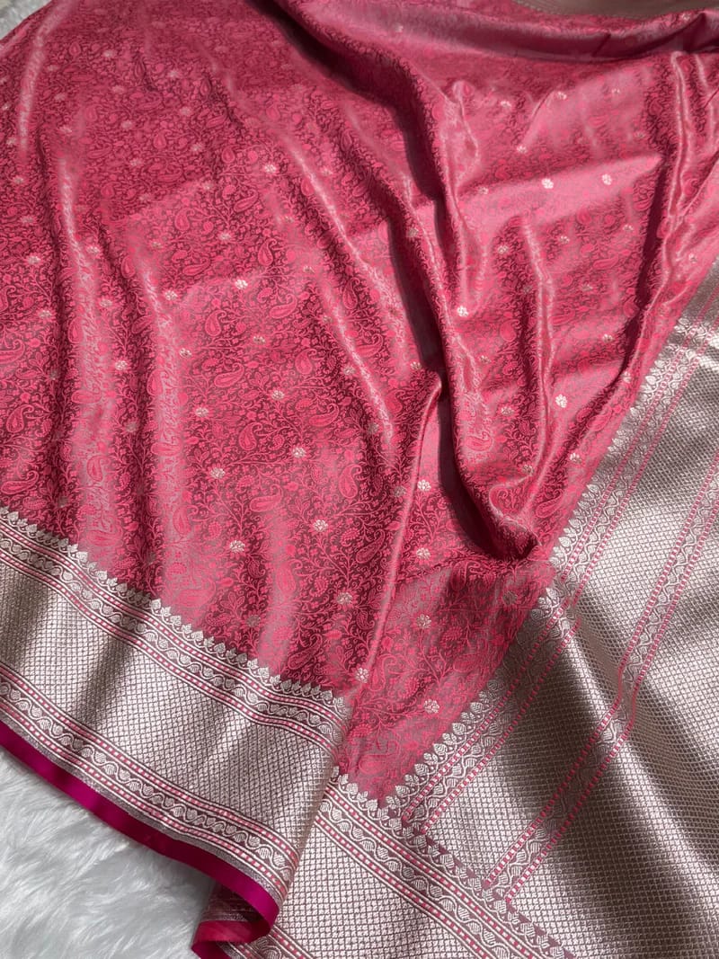 Close-up of a pink fabric with intricate patterns on a white background