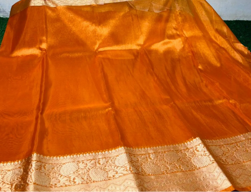 An orange Banarasi silk saree with a wide beige and gold zari border, laid out flat.