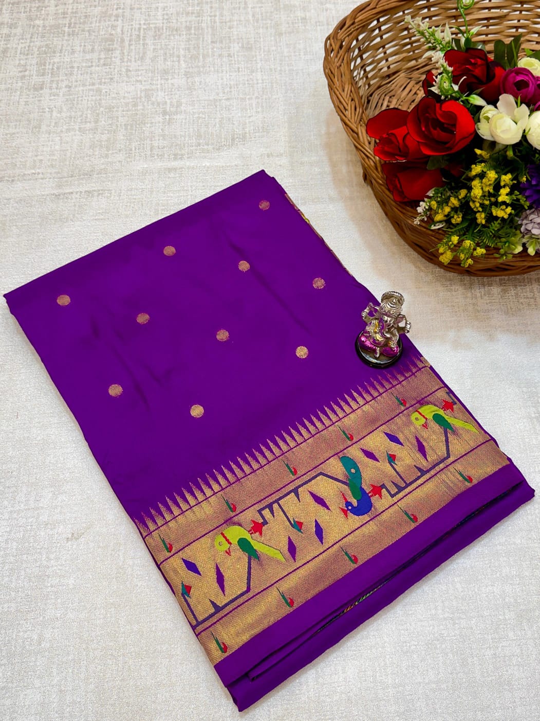 Purple saree with a decorative border on a light fabric background