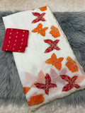 White fabric with red and orange butterfly patterns on a gray textured surface