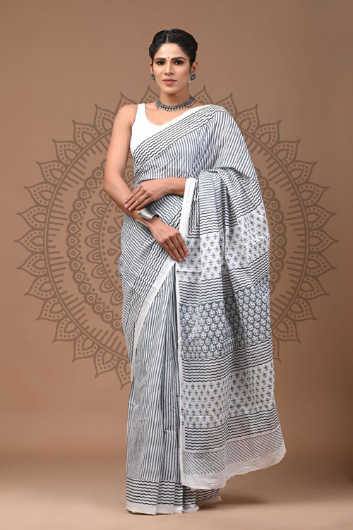 Woman wearing a black and white patterned saree on a brown background