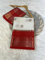 Red and white embroidered fabric on a wooden hanger against a white background
