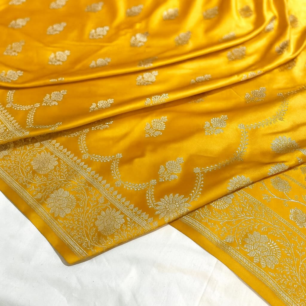 Yellow fabric with intricate gold patterns on a white background
